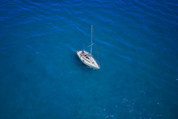 Aerial view to White yacht in blue sea. Drone photography