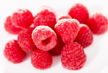 handful of raspberry berries on white background