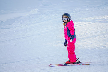 Little girl is learning to ski in ski resort. Winter season. 