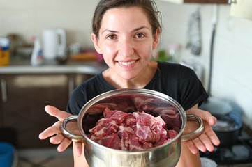 Girl holding saucepan with meat