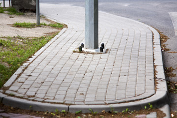 Nowy słup latarni ulicznej zamontowany na łuku chodnika z kostki © qrrr