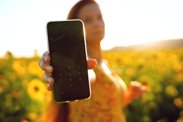 a girl on a yellow background holds a smartphone with a password