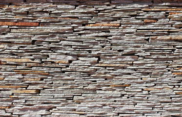 Stone wall texture and background made from pieces of old flat golden sandstone