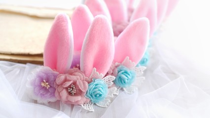 Fototapeta na wymiar Handmade flowers as headband hair accessory with bunny or rabbit ears as decoration in soft pastel colors