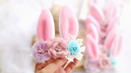Handmade flowers as headband hair accessory with bunny or rabbit ears as decoration in soft pastel colors
