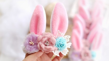 Fototapeta na wymiar Handmade flowers as headband hair accessory with bunny or rabbit ears as decoraiton in soft pastel colors