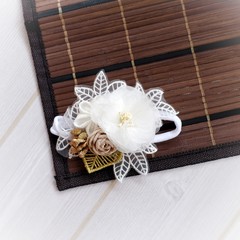 Handmade flower as headband hair accessory made out of fabric flowers in beautiful pastel colors place on wooden decoration and embellishment