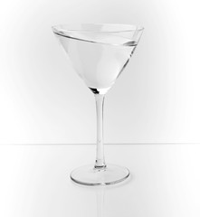 Copa de cocktail en posición surrealista,sobre fondo blanco