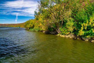 Vivid fall foliage reflects on the Dniester River, Moldova republic of.