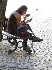 Kobieta z telefonem na ławce w parku