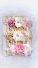 Handmade flower as headband hair accessory made out of fabric flowers in beautiful pastel colors place on vintage photo frame
