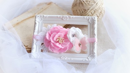 Headband flower with pastel color made out of flower fabric on white photo frame. The handmade floral is great for hair accessories with its colorful flower and beautiful for hair band.