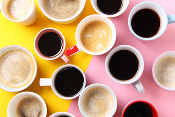 Close up of many different cups of coffee on yellow and pink background. Top view,flat lay,copy space.