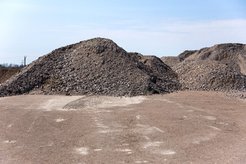 Industrial background with pile of gravel in front of the sky. Extraction of gravel. Construction...