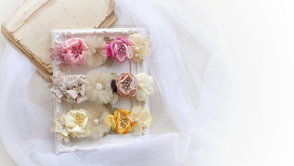 Fototapeta na wymiar Headband flower with pastel color made out of flower fabric on white photo frame. The handmade floral is great for hair accessories with its colorful flower and beautiful for hair band.