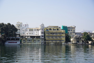 Fototapeta premium Multi-family residential buildings next to the lake. They provide the residents of the flats with direct contact with nature and water. Udaipur India - July 2020