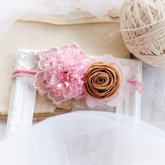 Handmade flower as headband hair accessory made out of fabric flowers in beautiful pastel colors on white photo frame