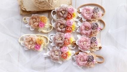 Fototapeta na wymiar Handmade flower headband hair accessory made out of fabric flowers in beautiful pastel colors