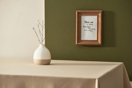 Still life with vase and photo frames on wooden table over white background
