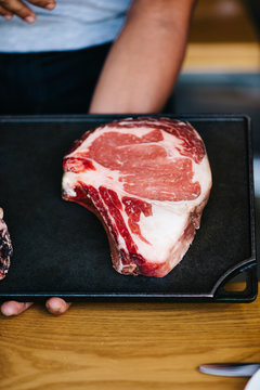 Restaurant Server Showing Today's Cuts of Meat