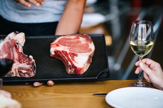 Restaurant Server Showing Today's Cuts of Meat