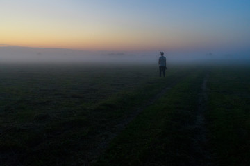 silhouette of a man walking in the fog