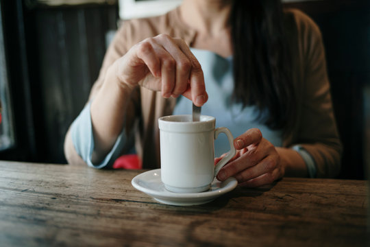Woman Stirring Her Coffee