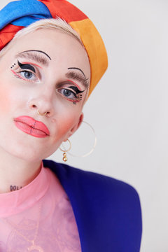 A close up of a beautiful woman wearing an eccentric makeup look.
