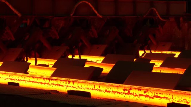 Metallurgical production, heavy industry, engineering, steelmaking. Red hot steel metal billets after molten steel casting. Continuous casting machine. Hot steel pouring in steel plant.
