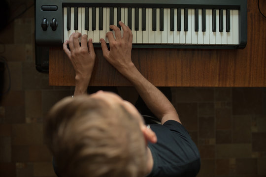 photo of a guy&sbquo;&Auml;&ocirc;s hands on electronic keys on top