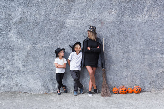 Mom and two children in costumes for Halloween have fun.