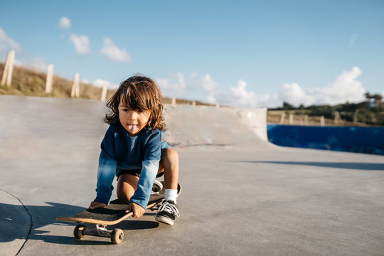 Little kid with skateboard in skatepark