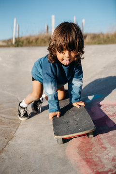 Little kid with skateboard in skatepark