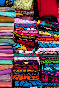 Colorful sarapes stacked in a pile