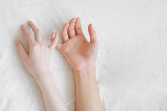 two hands on a white sheet
