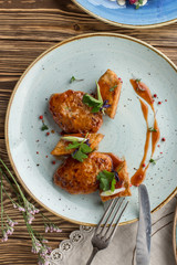 chicken fillet in sweet sauce on blue plate on wooden table