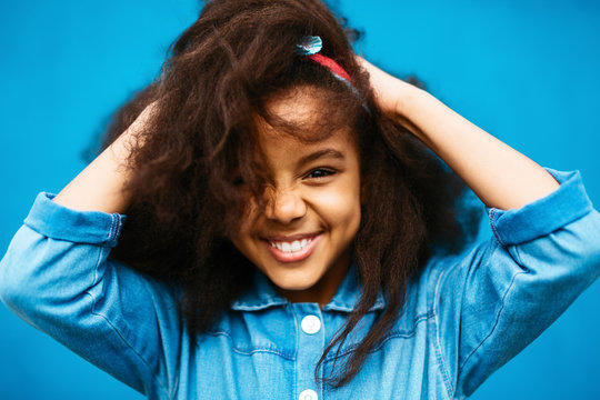 Cheerful black girl rumpling hair