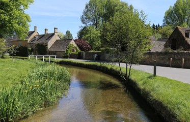 Fototapeta na wymiar The River Eye running through the beautiful Cotswold village of Lower Slaughter, Gloucestershire, England.