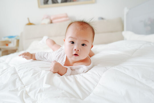 portrait of cute baby girl lying on bed