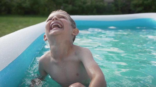 Laughing boy in garden pool