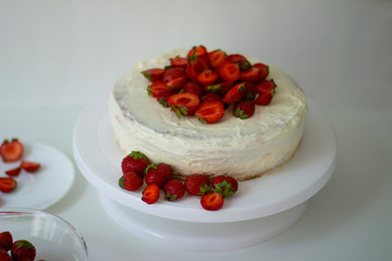 Homemade cake with strawberries and cheese cream on  white plate.