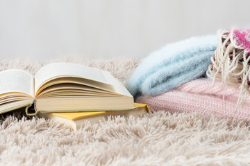 Warm clothes, books, the concept of a cozy comfortable home.