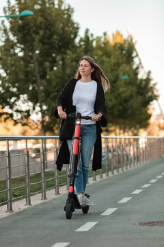 Woman taking a ride with an electric scooter in the city.