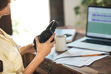 Podcaster working with audio records on laptop