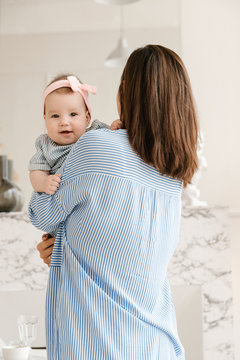 Young Mother Holding her Baby and Baby Looking at Camera