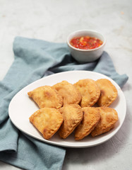Typical Colombian empanadas usually served with spicy sauce on concrete surface