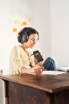 Female podcaster making recordings at home