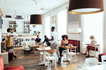 Waitress and clients in cozy cafe
