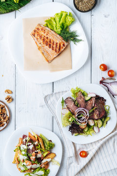 Meat and fish dishes on table