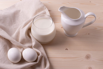 Fototapeta na wymiar two white eggs and milk as calcium concept. minimalism style.